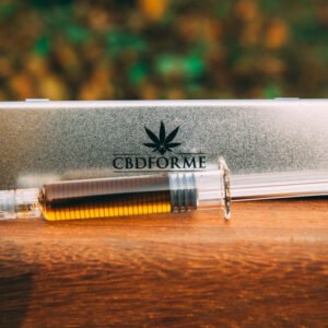 Vandopløselig CBD dryppet ned i et glas vand på et bord