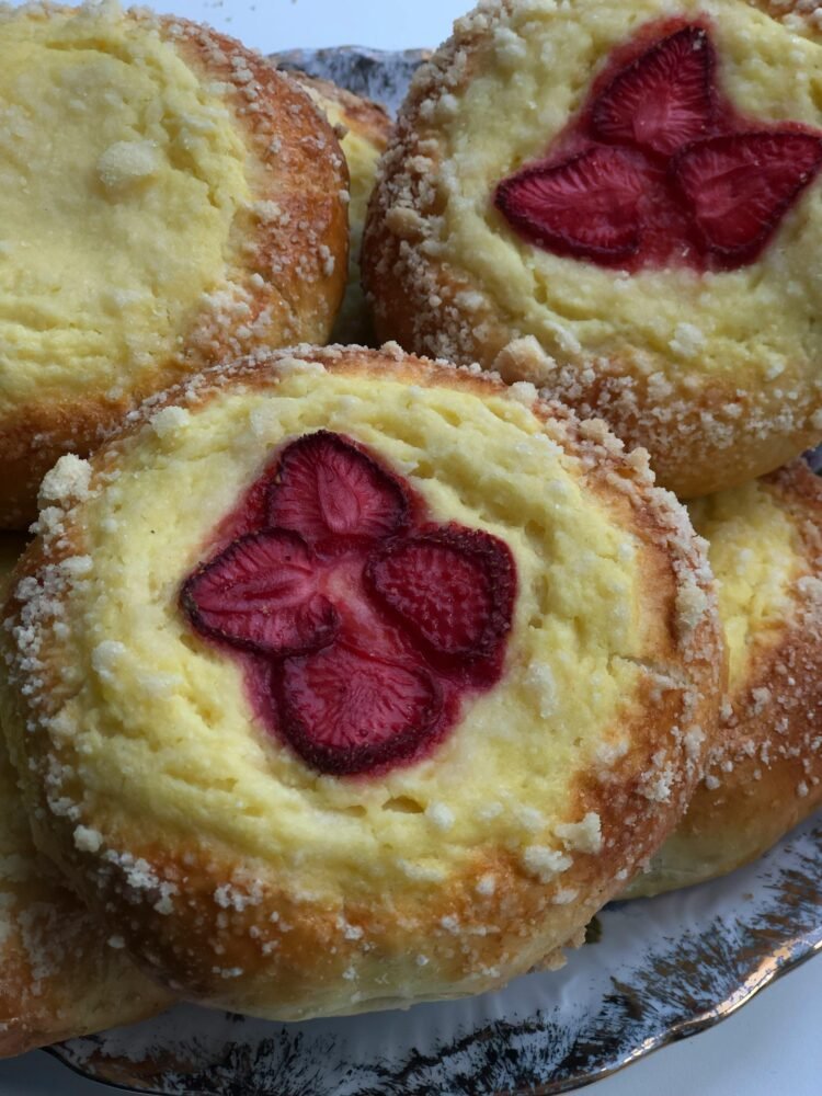 Close-up of fresh strawberry cheese danish pastries arranged in a pile, showcasing their texture.